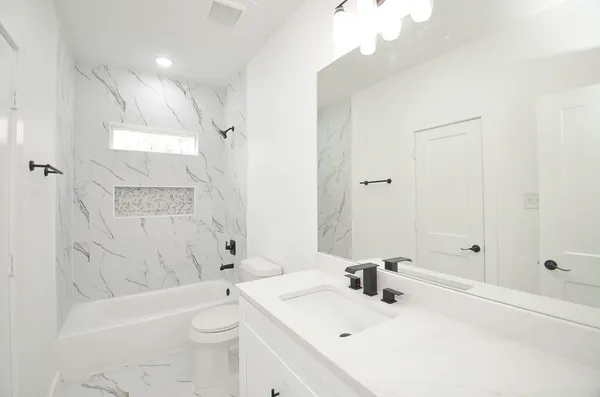 a bathroom with a sink a toilet and shower