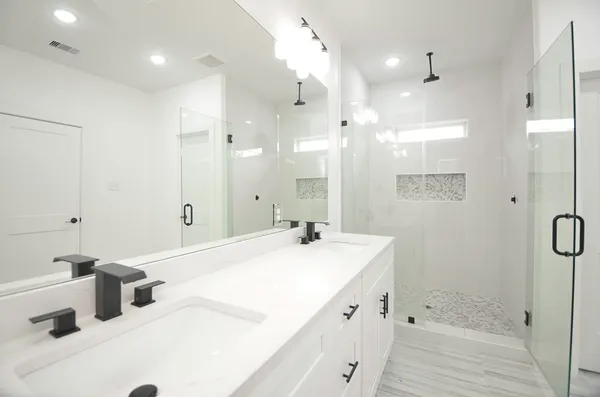 a bathroom with a tub sink shower and mirror