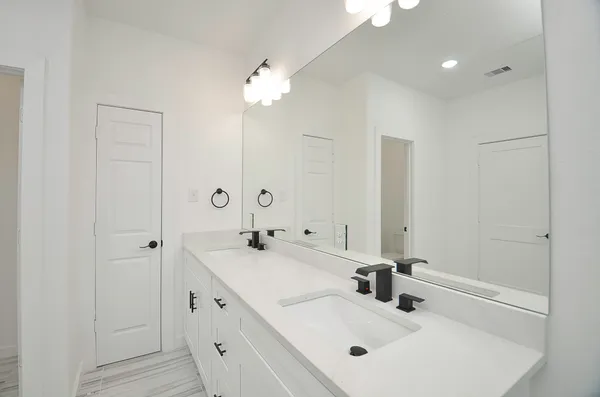 a bathroom with double vanity sink and a mirror