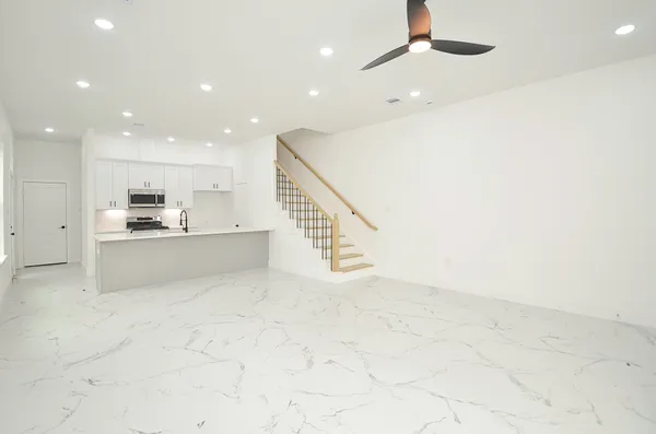 a view of kitchen with kitchen island microwave and cabinets