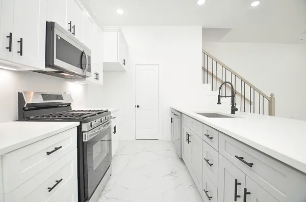 a kitchen with stainless steel appliances a stove microwave and cabinets