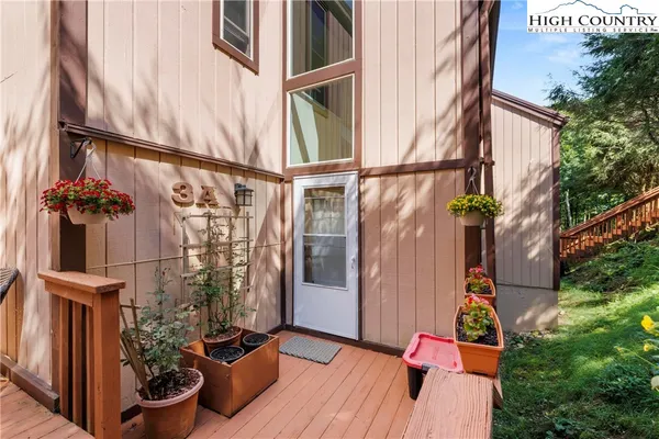 a view of balcony with wooden floor and potted plants