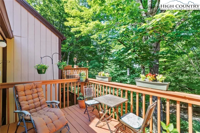 a view of a balcony with wooden floor and outdoor seating