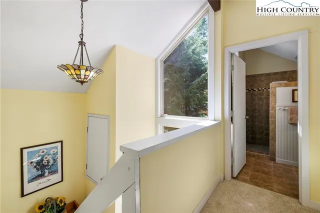 a view of a hallway with a window and chandelier