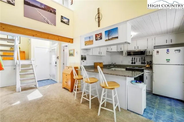 a kitchen with a table chairs refrigerator and cabinets