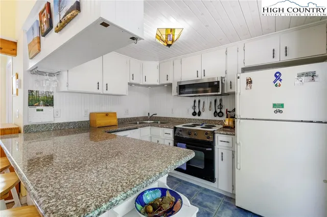 a kitchen with stainless steel appliances granite countertop a refrigerator sink stove and cabinets
