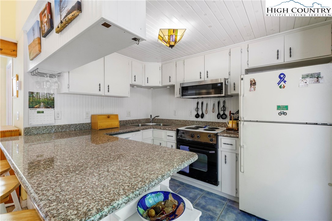 108 Northridge Road, Unit 3A Beech Mountain, NC 28604 - Photo 10 of 23 a kitchen with stainless steel appliances granite countertop a refrigerator sink stove and cabinets
