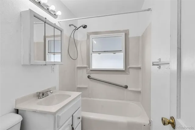 a bathroom with a tub sink vanity and mirror