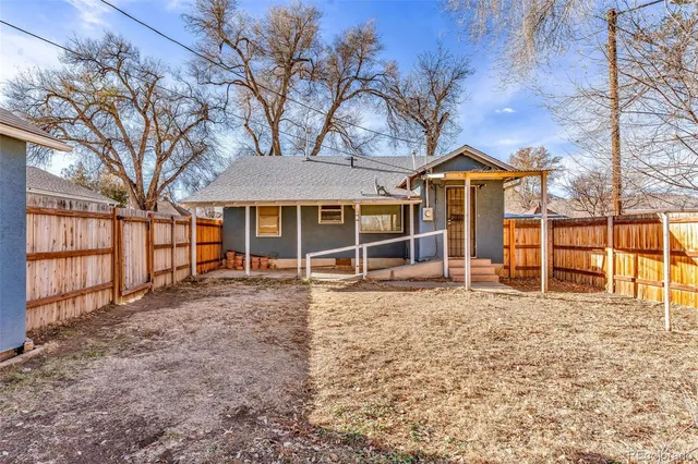 a view of a house with a large tree and a yard