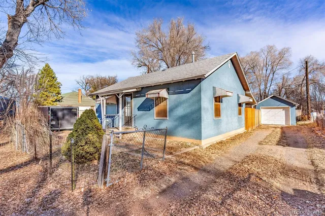 a view of a house with backyard and a tree