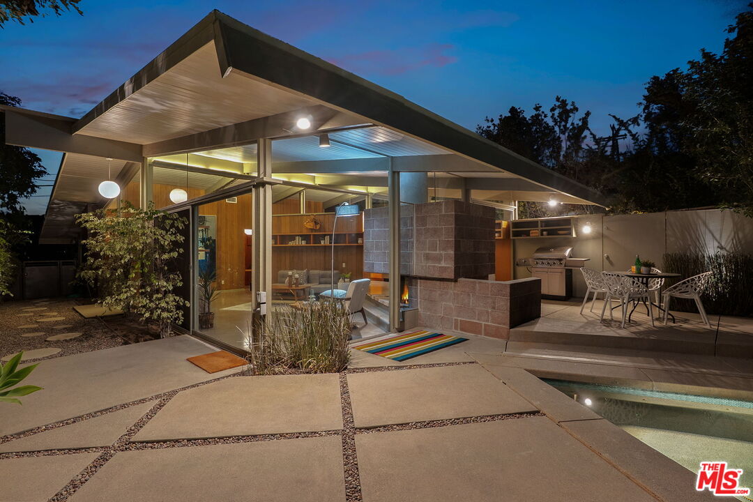 12412 Deerbrook Lane Los Angeles, CA 90049 - Photo 1 of 30 a view of a patio with a table and chairs under an umbrella
