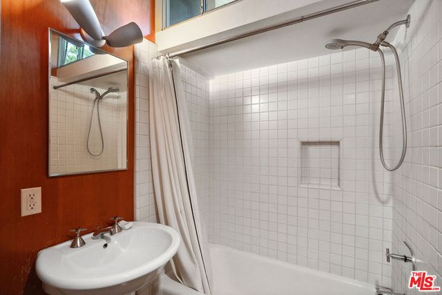 a bathroom with a sink a mirror and a shower