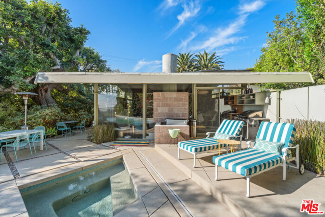 12412 Deerbrook Lane Los Angeles, CA 90049 - Photo 25 of 30 a view of a patio with a table and chairs