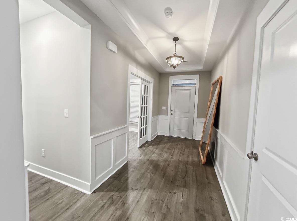 2108 Ballast Court Myrtle Beach, SC 29579 - Photo 14 of 37 Foyer featuring a tray ceiling, dark wood-style flooring, a decorative wall, and a wainscoted wall
