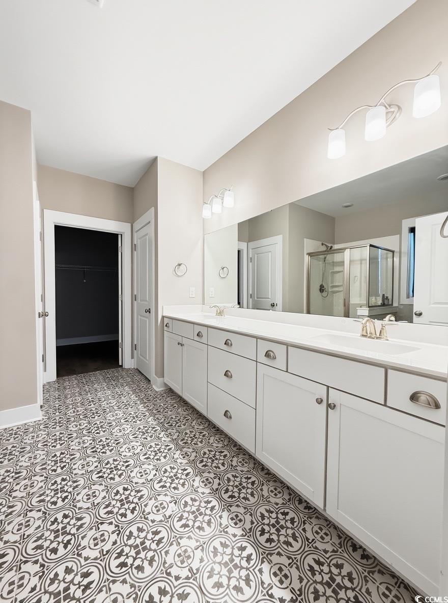 2108 Ballast Court Myrtle Beach, SC 29579 - Photo 19 of 37 Bathroom with a spacious closet, double vanity, and a stall shower