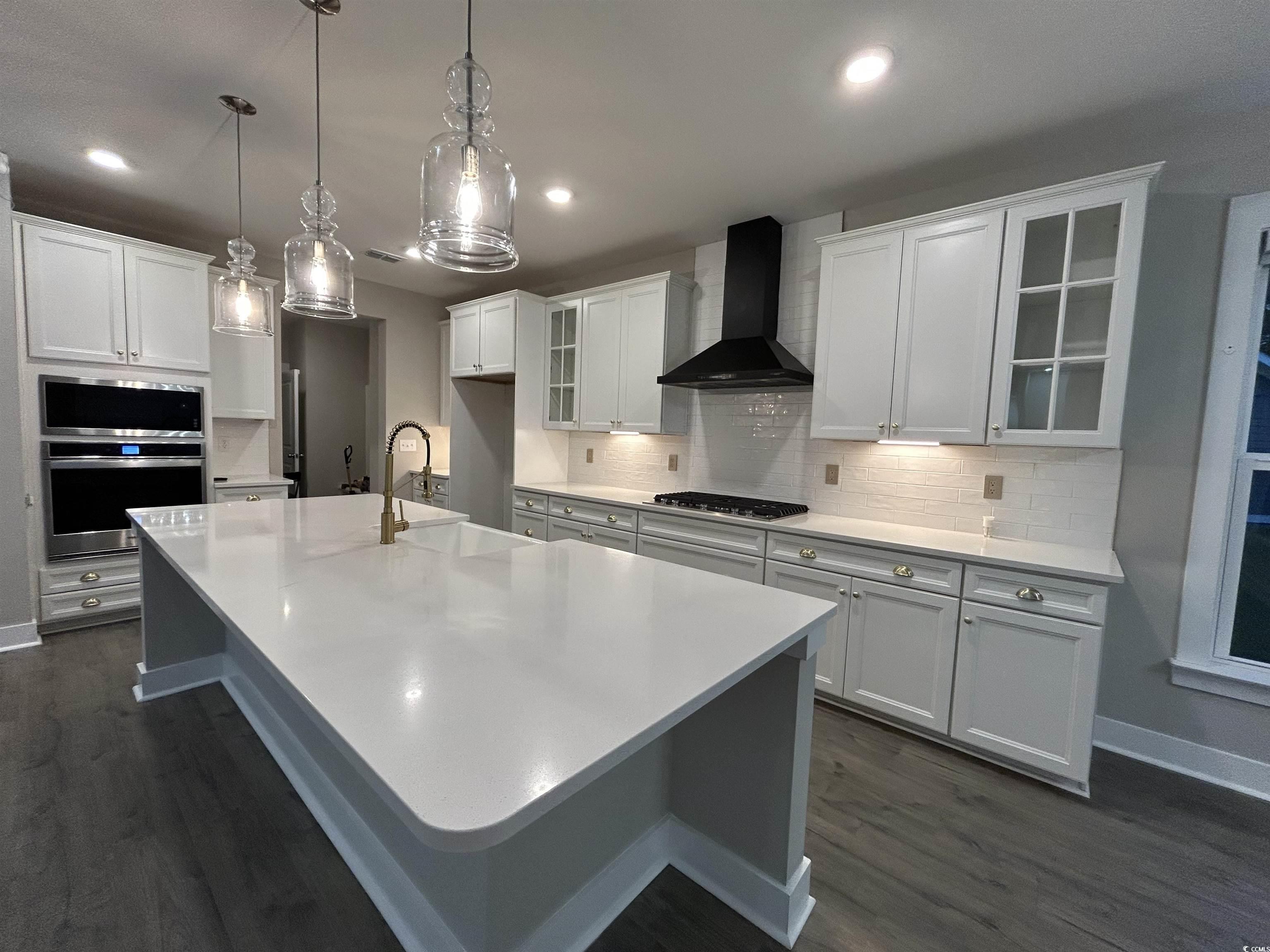 2108 Ballast Court Myrtle Beach, SC 29579 - Photo 5 of 37 Kitchen with glass insert cabinets, white cabinets, wall chimney exhaust hood, and recessed lighting