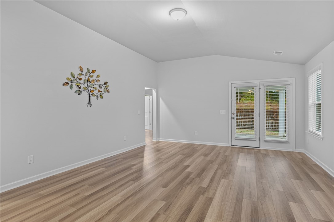 24 Chalet Court Anderson, SC 29621 - Photo 14 of 39 This airy living space features warm wood flooring, offering a seamless transition to the outdoors through patio doors.