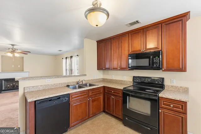 a kitchen with stainless steel appliances granite countertop a stove microwave and sink