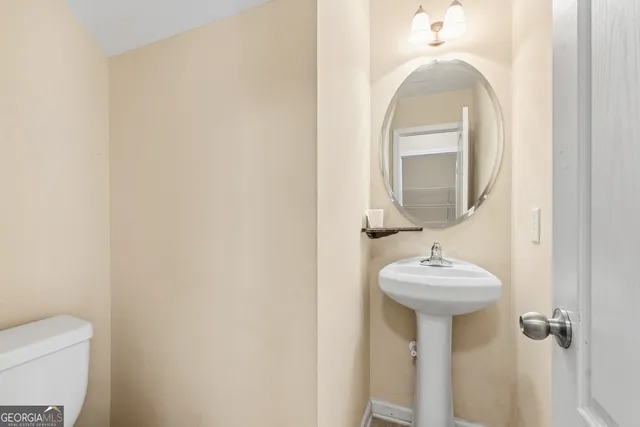 a bathroom with a sink and mirror with toilet