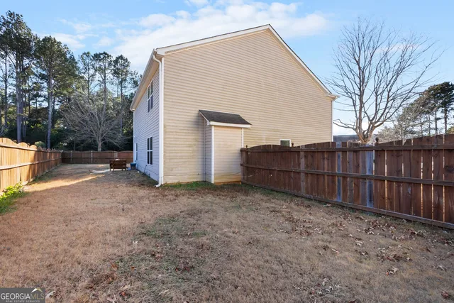 a view of backyard with wooden fence