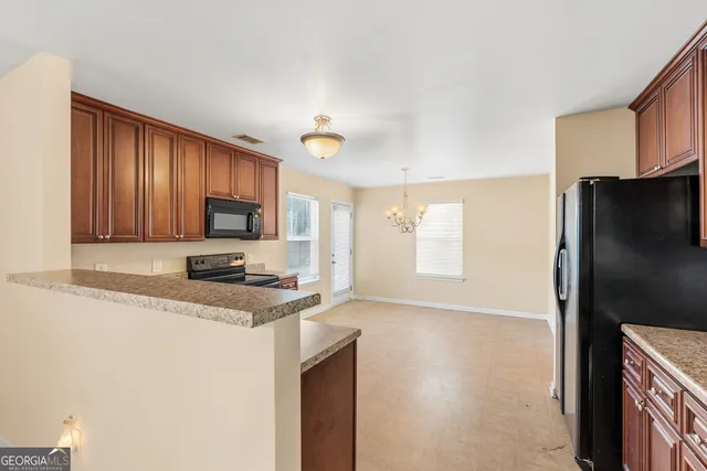 a kitchen with stainless steel appliances granite countertop a refrigerator stove top oven a sink and dishwasher