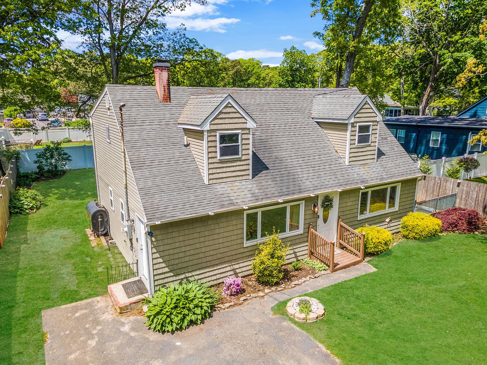 Cape cod house featuring a chimney and a shingled roof