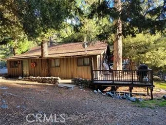 a front view of a house with a yard and wooden fence