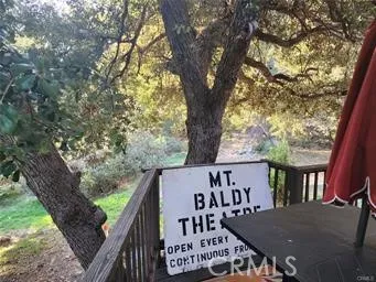 a view of a wooden chairs and table in the balcony