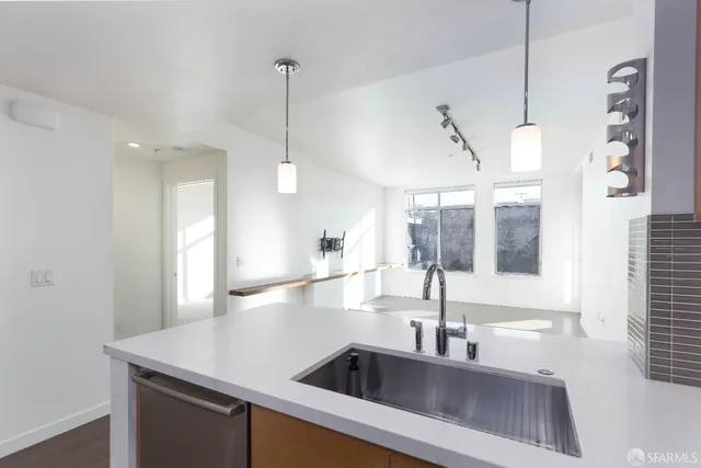 a kitchen with a sink a counter space and windows