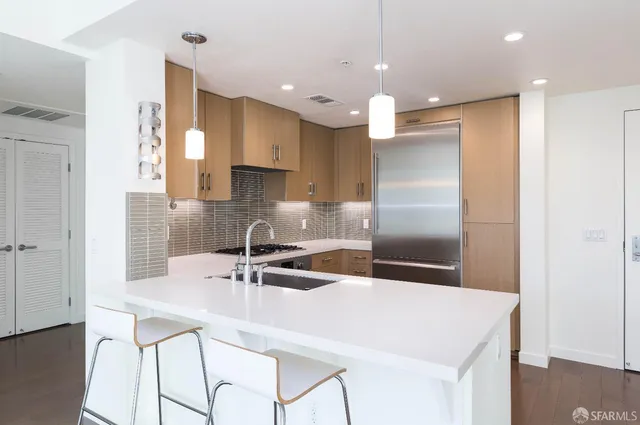 a kitchen with kitchen island a sink and a refrigerator