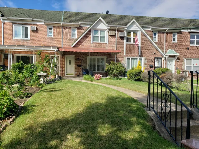 a front view of a house with yard and green space