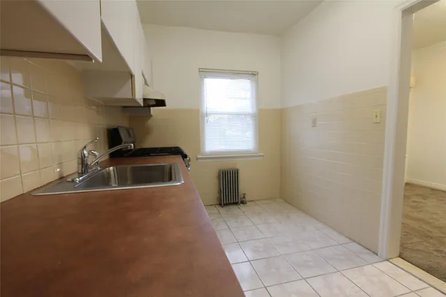 a kitchen with stainless steel appliances a sink a stove a microwave a window and white cabinets