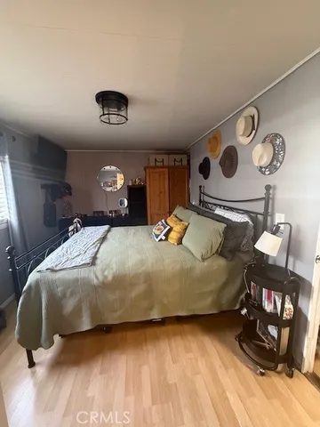 a bedroom with a bed and a table with wooden floor