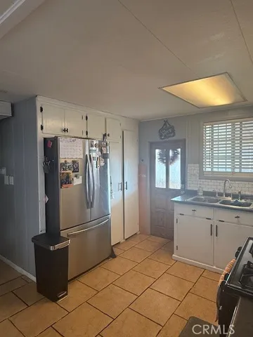 a kitchen with granite countertop a refrigerator and a sink