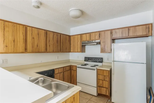 a kitchen with a stove a refrigerator and a sink
