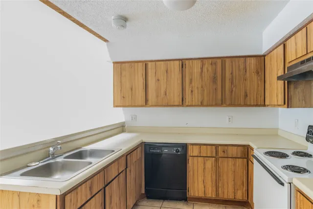 a kitchen with a sink cabinets and a stove top oven