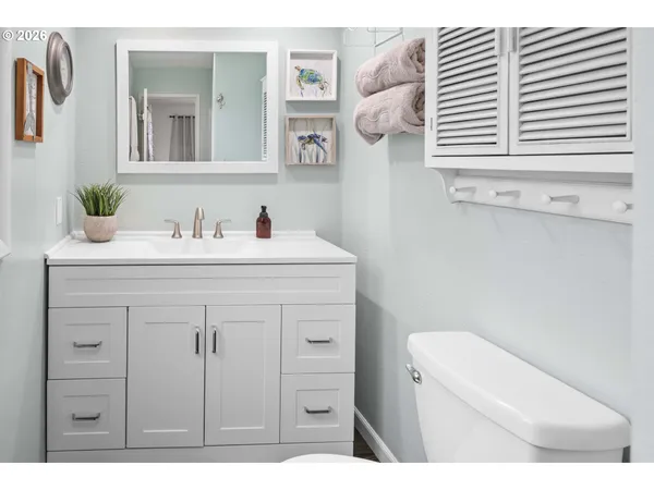 a bathroom with a sink a toilet and a window