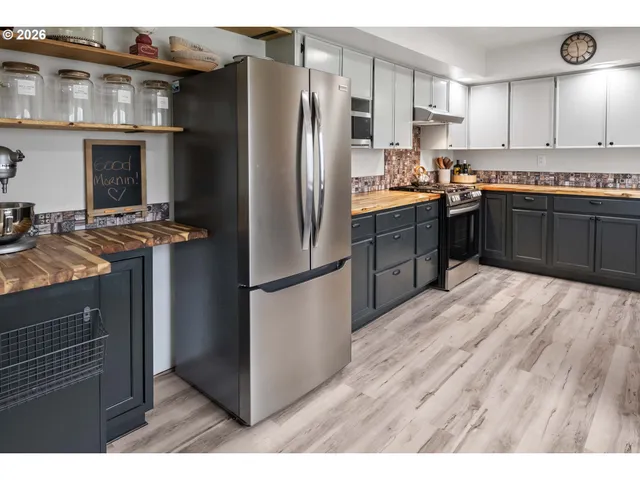 a kitchen with stainless steel appliances granite countertop a refrigerator a stove a sink and a microwave