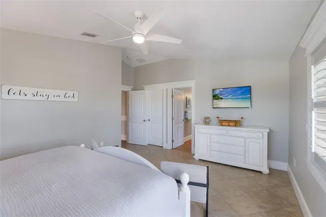 a bedroom with a large bed and a lamp on the dresser