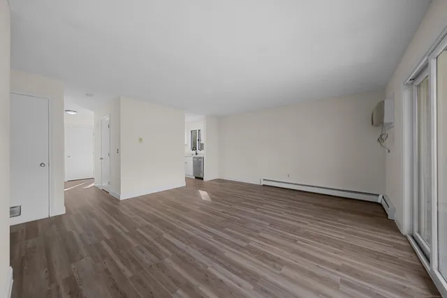 a view of an empty room and wooden floor
