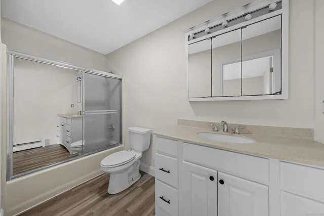 a bathroom with a granite countertop sink toilet and shower