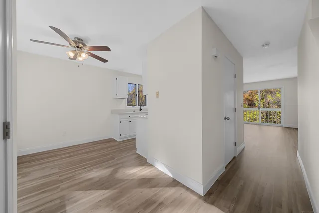 a view of a workspace with wooden floor and a ceiling fan