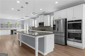 a kitchen with stainless steel appliances a stove a sink and a refrigerator
