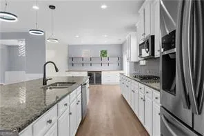 a kitchen with stainless steel appliances granite countertop a sink a stove and a refrigerator