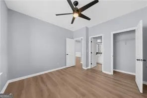 a view of a room with wooden floor and a ceiling fan