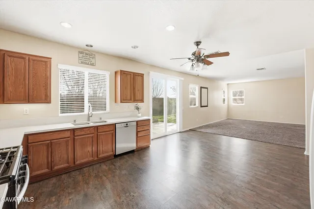 a large kitchen with granite countertop a stove a sink a window and dining table