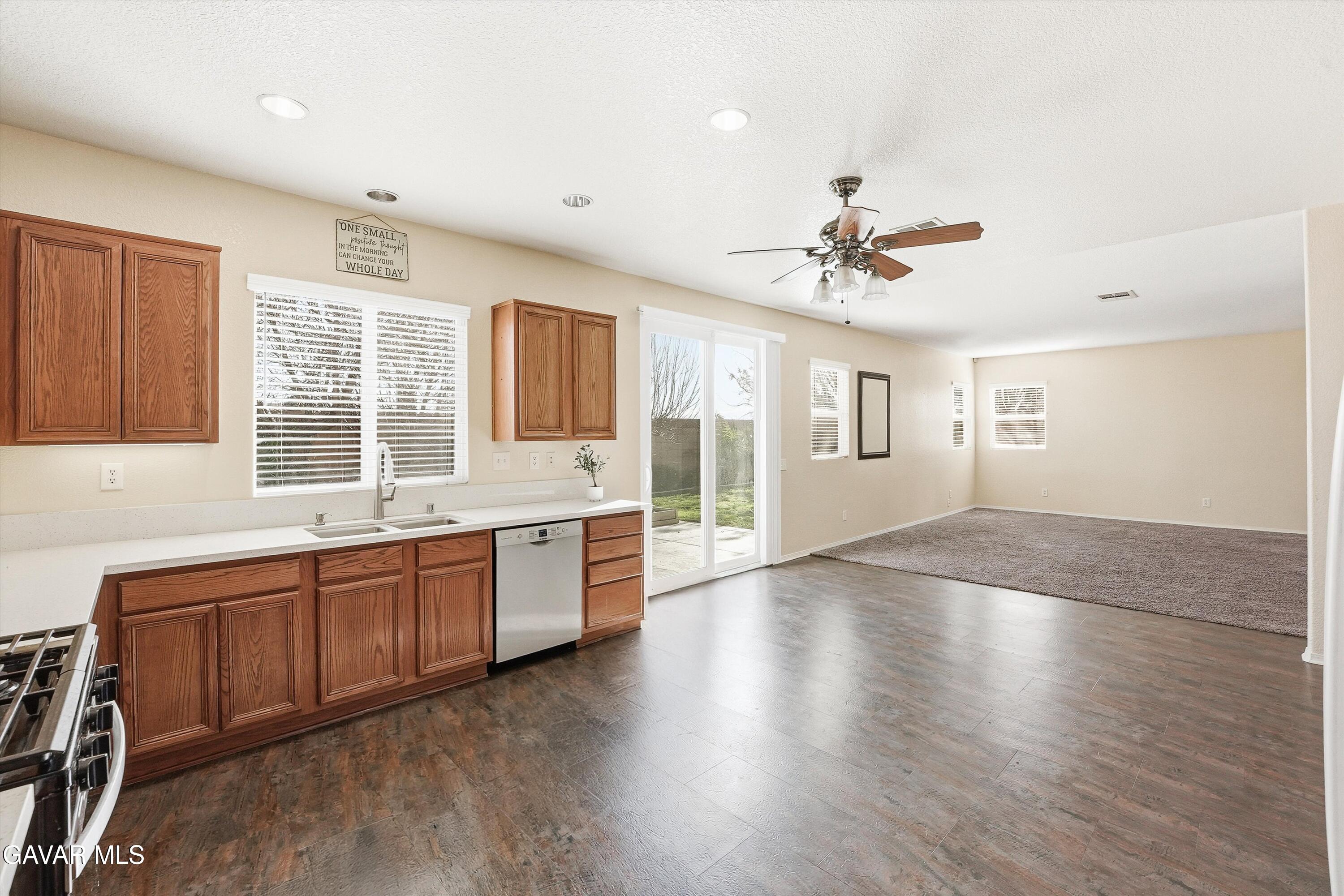 44232 Begonia Street Lancaster, CA 93535 - Photo 13 of 39 a large kitchen with granite countertop a stove a sink a window and dining table