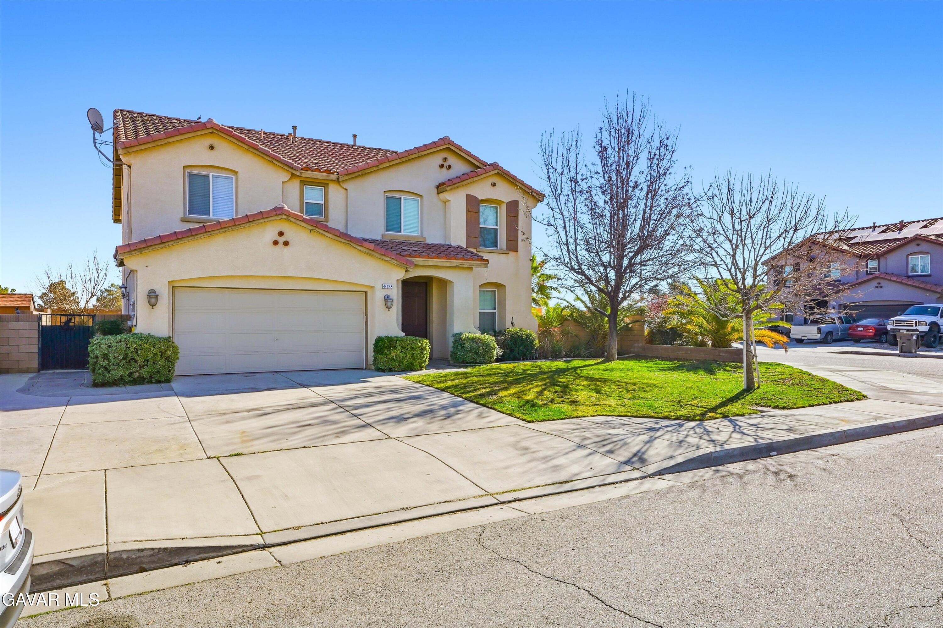 44232 Begonia Street Lancaster, CA 93535 - Photo 2 of 39 a front view of a house with a yard and garage