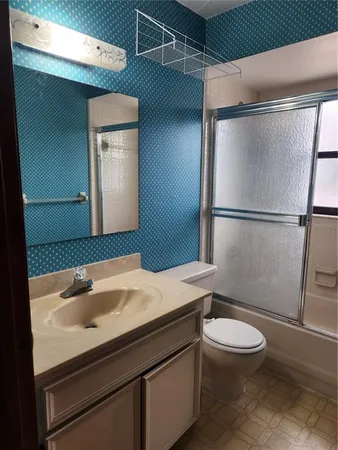 a bathroom with a sink a toilet and a mirror