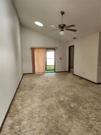 en empty room with windows and ceiling fan